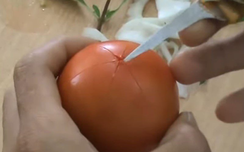 Making 2 additional diagonal cuts to divide the tomato into 6 equal parts