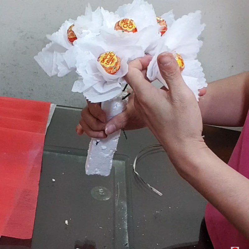 Step 2 Wrap with paper and insert flowers Bouquet from lollipop