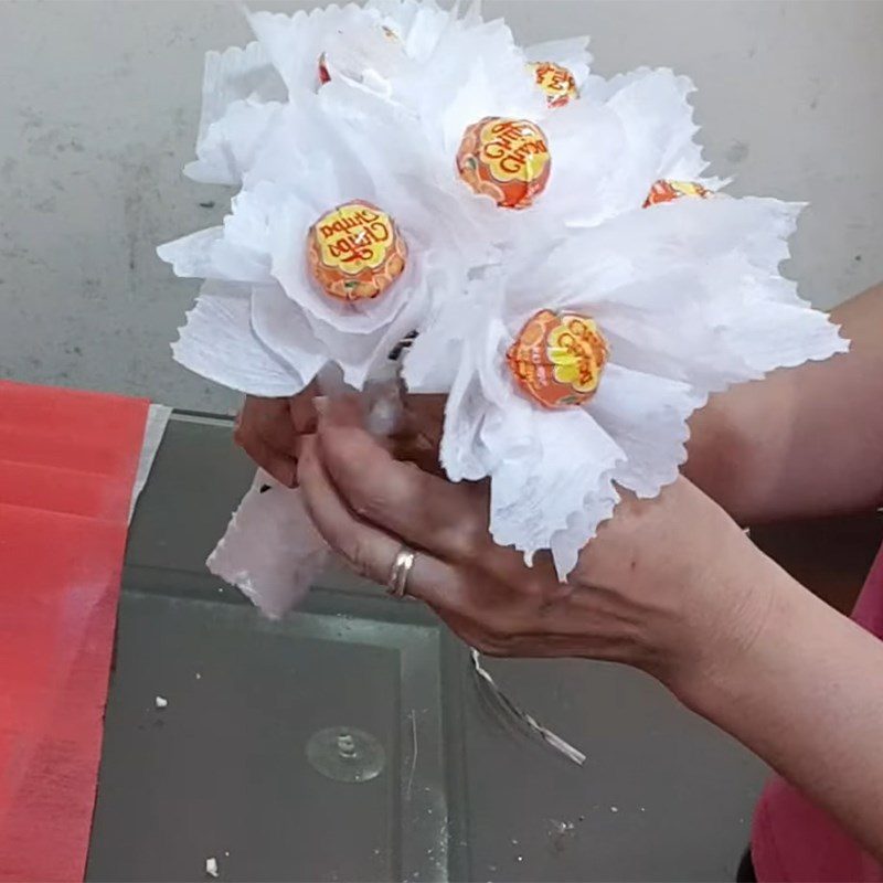 Step 2 Wrap with paper and insert flowers Bouquet from lollipop