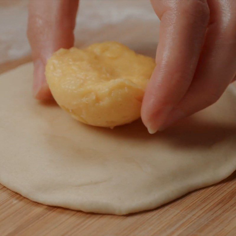 Step 5 Roll out the dough and wrap the mango custard filling Mango custard bun